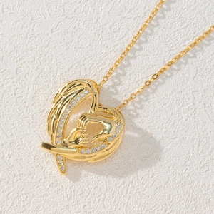 Detail of 18k gold heart pendant with crystal hand-in-hand motif on white texture