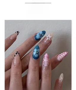 Dettaglio di unghie finte stiletto lunghe con decorazioni floreali blu e strass