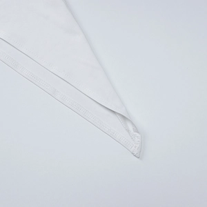 Detailed macro view of high-quality double-needle stitching on a white summer dress hemline