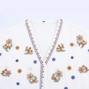 White cotton linen V-neck shirt with colorful floral embroidery and textured fabric