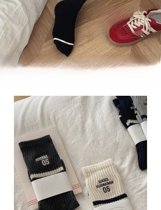 Detail of ribbed cotton mid-calf socks in grey and cream with vintage embroidery