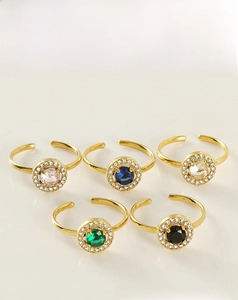 Detail of five adjustable gold steel rings with colorful zircon stones in a set