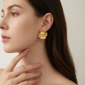 Vintage gold shell earrings with center pearl on model, elegant French retro style