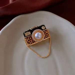 Vintage camera brooch with black enamel, pearl lens and sparkling zircon accents