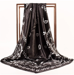 Detail of black and white paisley print on soft satin fabric draped on a metal stand