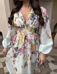 Close-up of floral print dress featuring a deep V-neckline and elegant cinched waistline
