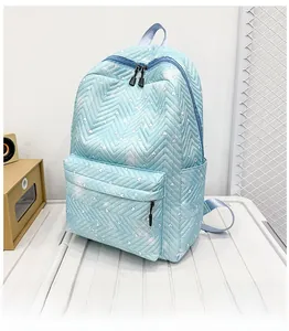 Detalle de mochila azul claro con acolchado ondulado, motivos de corazones y bolsillo