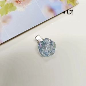 Aurora blue camellia flower hair clip with metal duckbill base on white background