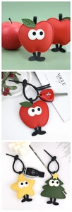 Detail of Christmas tree and apple PU leather keychains with textured finish