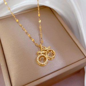 Elegant gold cherry pendant necklace with zircon stones on a soft silk background