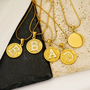 Gold plated stainless steel round coin necklace with white enamel capital letters