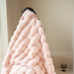 Close-up of soft pink faux rabbit fur blanket showing luxurious fluffy plush texture