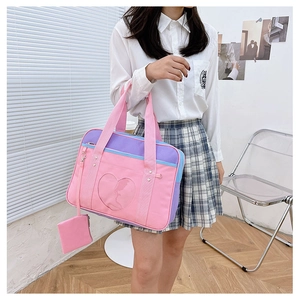 Detail of pink and purple JK uniform bag with heart window and mini pouch pendant