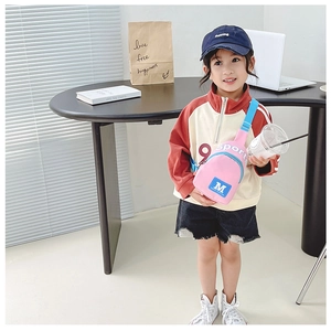 Détail du sac de poitrine en nylon rose et bleu pour enfants avec sangle et logo sport
