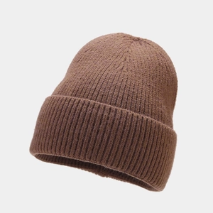 Close-up of the fine ribbed texture and thick cuff on a warm coffee brown knit beanie