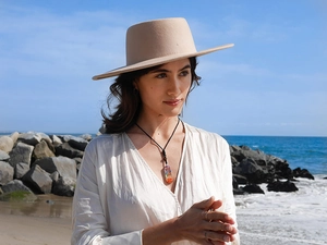Outdoor lifestyle shot of a seven chakra gemstone necklace on a sandy beach background