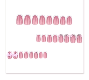 Detailed view of pink French press-on nails with 3D bows, flowers and shiny rhinestones