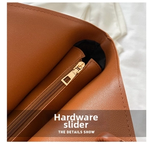 Close-up of golden zipper hardware and litchi texture on brown leather tote bag