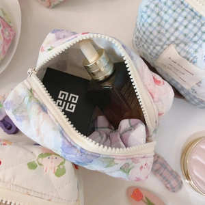 Detailed macro view of quilted cotton makeup bag with floral patterns and zipper closure