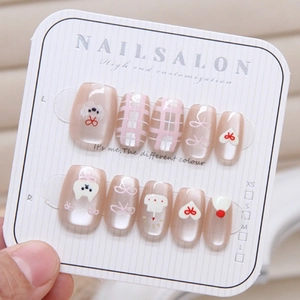 Detailed view of cat-eye press-on nails with cartoon puppy, heart and 3D bow designs
