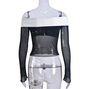 Détail d'un haut en tulle à épaules dénudées avec maille noire et décolleté blanc contrasté