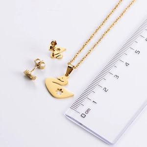 Detail view of golden swan necklace and earrings set with scale for size reference