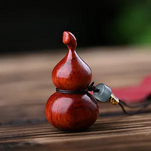 Macro shot of sandalwood gourd keychain with dark red wood grain and blue bead