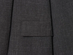 Detailed macro view of charcoal grey blazer pocket flap with premium stitching detail