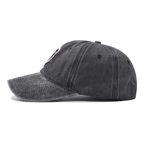Dettaglio del ricamo rosa sul berretto da baseball in cotone nero lavato vintage