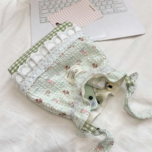 Détails de motifs mignons et dentelle blanche sur un petit sac à bandoulière vert pastel