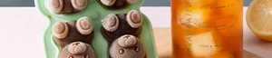 Close-up of green silicone mold creating a brown bear-shaped coffee ice cube