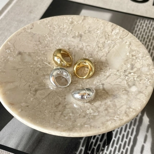 Set of chunky gold and silver minimalist rings with cubic zirconia on marble tray