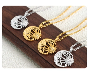 Detailed close-up of sun and moon pendant necklaces in gold and silver on wooden display