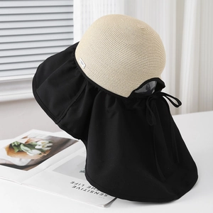 Dettaglio cappello da sole con tesa larga, protezione nuca e fiocco decorativo sul retro