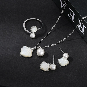 Elegant shell pearl jewelry set including necklace, open ring, and stud earrings in silver