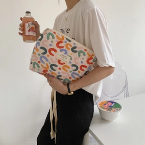 Quilted floral makeup bag with multi-color horseshoe print held by a model
