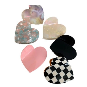Assorted medium heart-shaped acetate hair claws in pink, checkerboard, and stone patterns