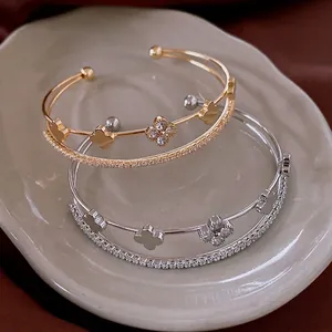 Luxurious gold and silver four-leaf clover open bangles with zircon pavé accents
