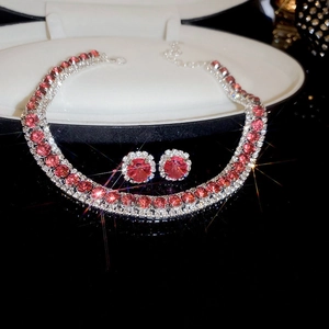 Detailed view of red gemstone jewelry set with necklace and earrings on a black surface