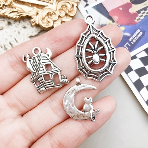 Handheld silver alloy Halloween charms featuring haunted house, spider web, and cat on moon