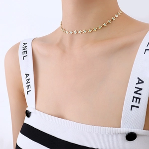 Gold-plated choker necklace with turquoise-colored floral links on a model's collarbone