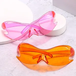 Y2K futuristic batwing wrap sunglasses in neon pink and orange on geometric display stands
