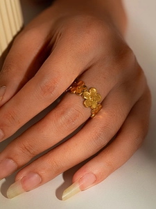 Detailed close-up of a gold floral eternity ring featuring connected five-petal flowers