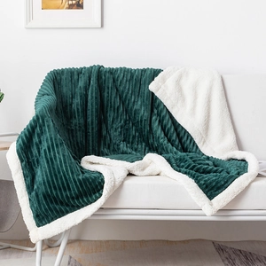 Detail of dark green striped flannel blanket with thick white sherpa lining texture