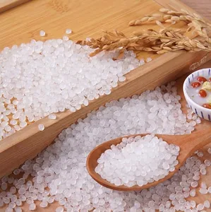Close-up of translucent white resin beads in a wooden spoon for DIY slime filling