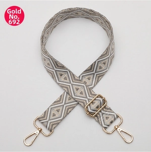 Close-up of adjustable woven shoulder strap with geometric diamond patterns and gold hooks