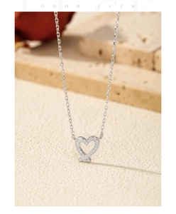Detailed view of S925 sterling silver hollow heart pendant with sparkling moissanite stones