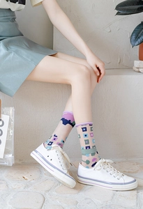 Detail of sheer mesh crew socks featuring colorful geometric patterns and slouchy ankle style