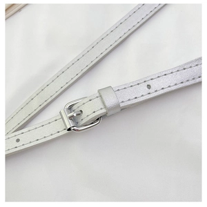 Close-up of silver synthetic leather bag strap with metal buckle and detailed stitching