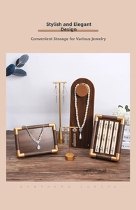 Detail of walnut wood jewelry display set with gold metal stands for necklaces and rings